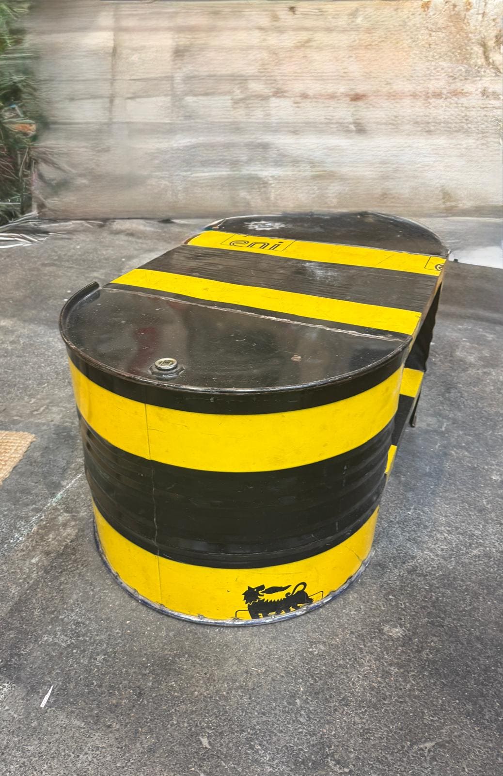 Bidon en métal jaune et noir rayé.